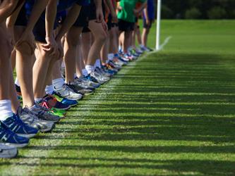 running feet lined up on field